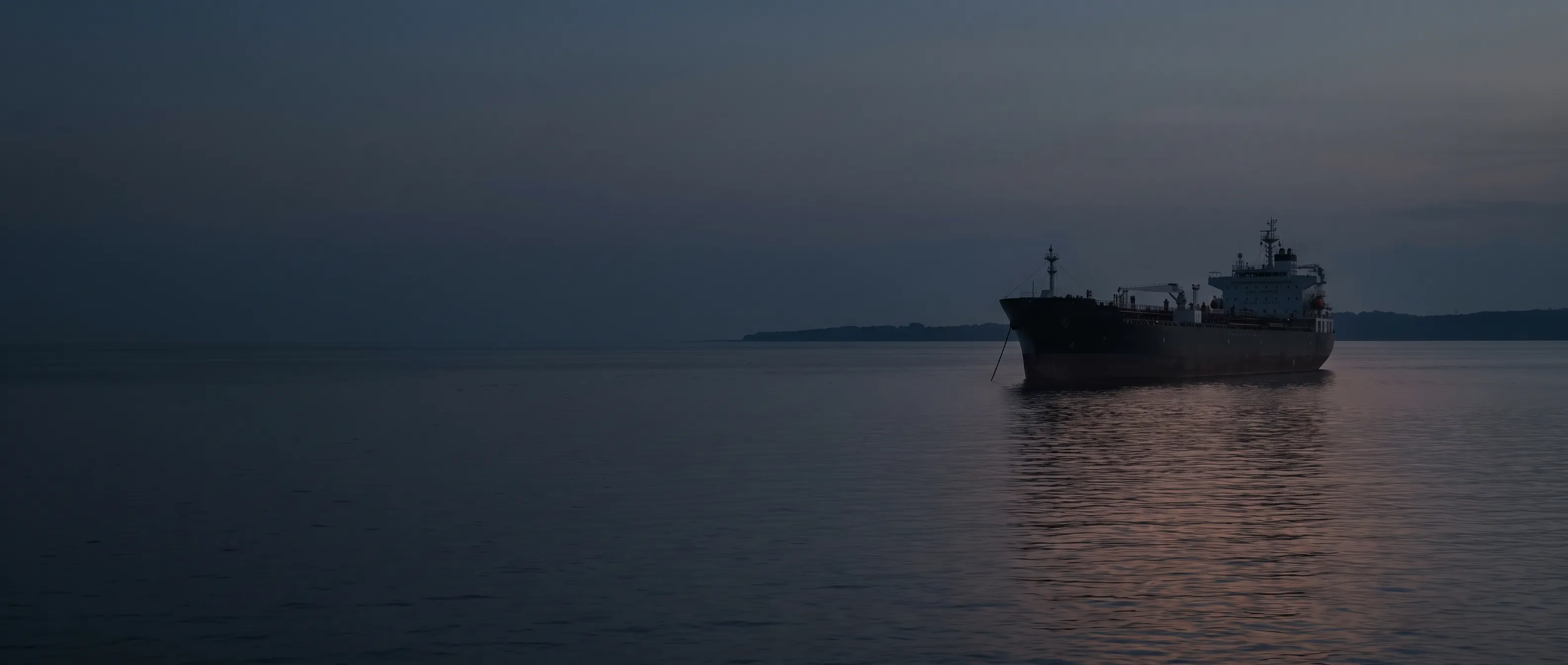 Tanker at anchor in a roadstead at sunset