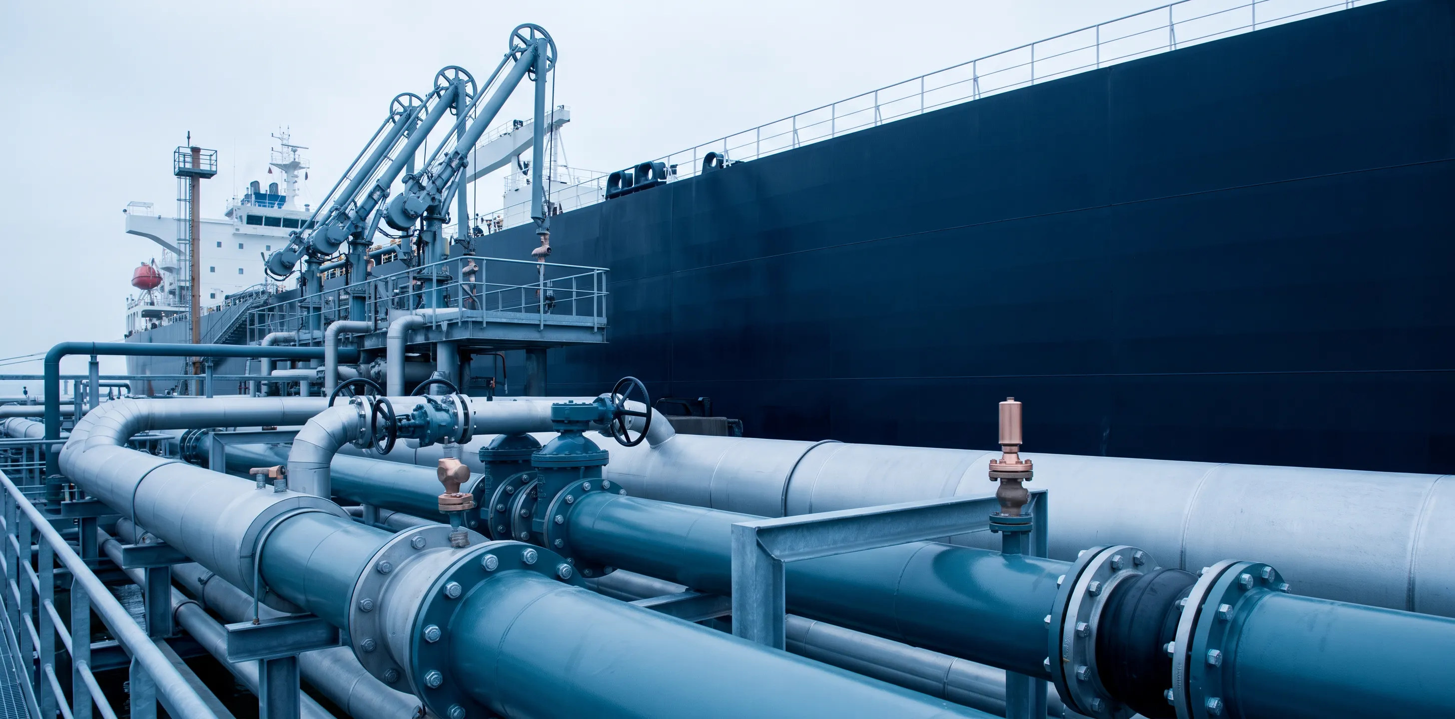 Oil terminal infrastructure with pipelines and loading arms serving a berthed tanker